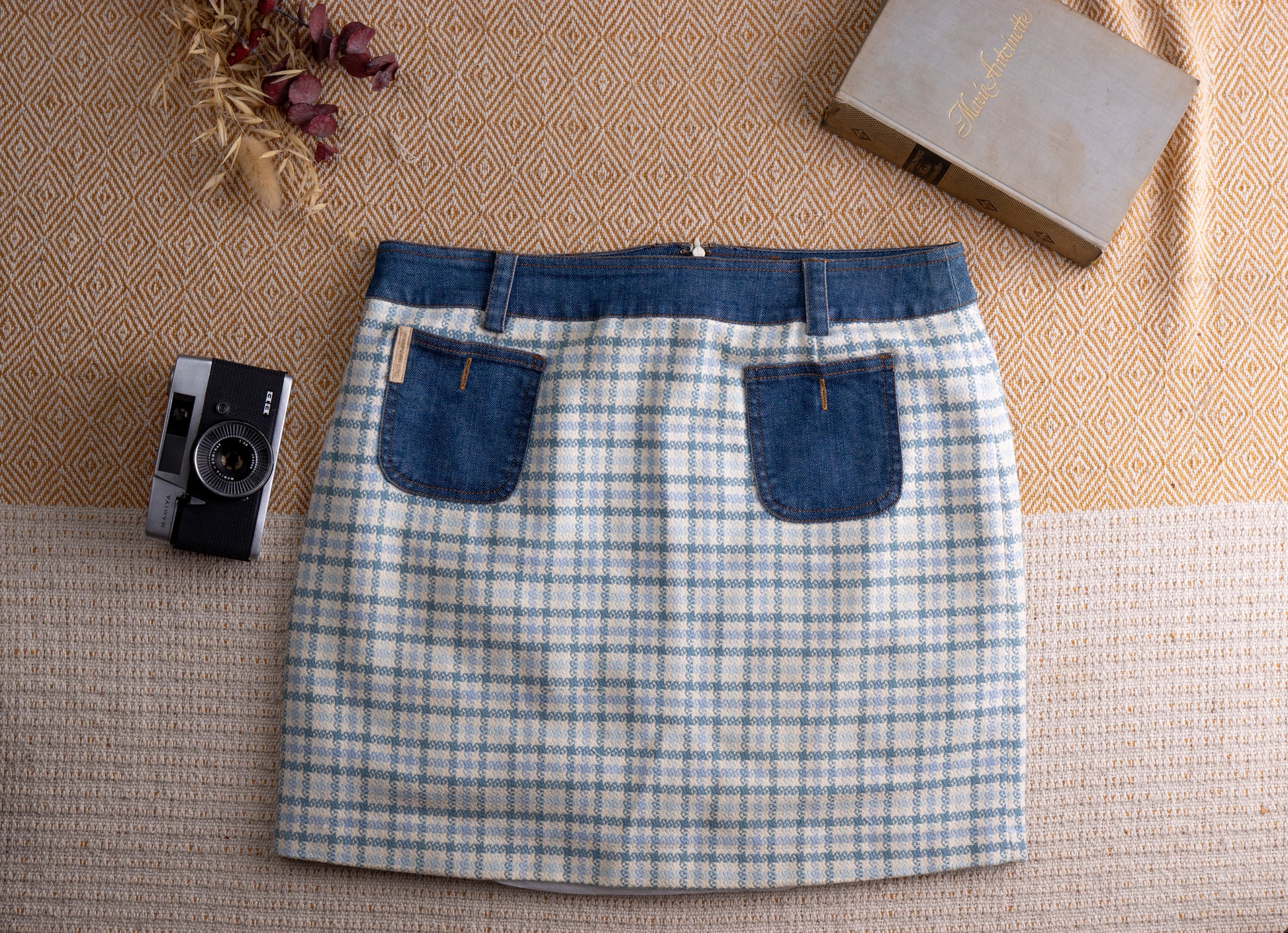 Vintage D&G Dolce Gabbana Y2K Mixed Media Mini Skirt – pale blue and white houndstooth tweed body with contrasting indigo denim waistband, two denim patch pockets with gold D&G logo patch, back zip closure, straight mini silhouette, flat lay editorial shot
