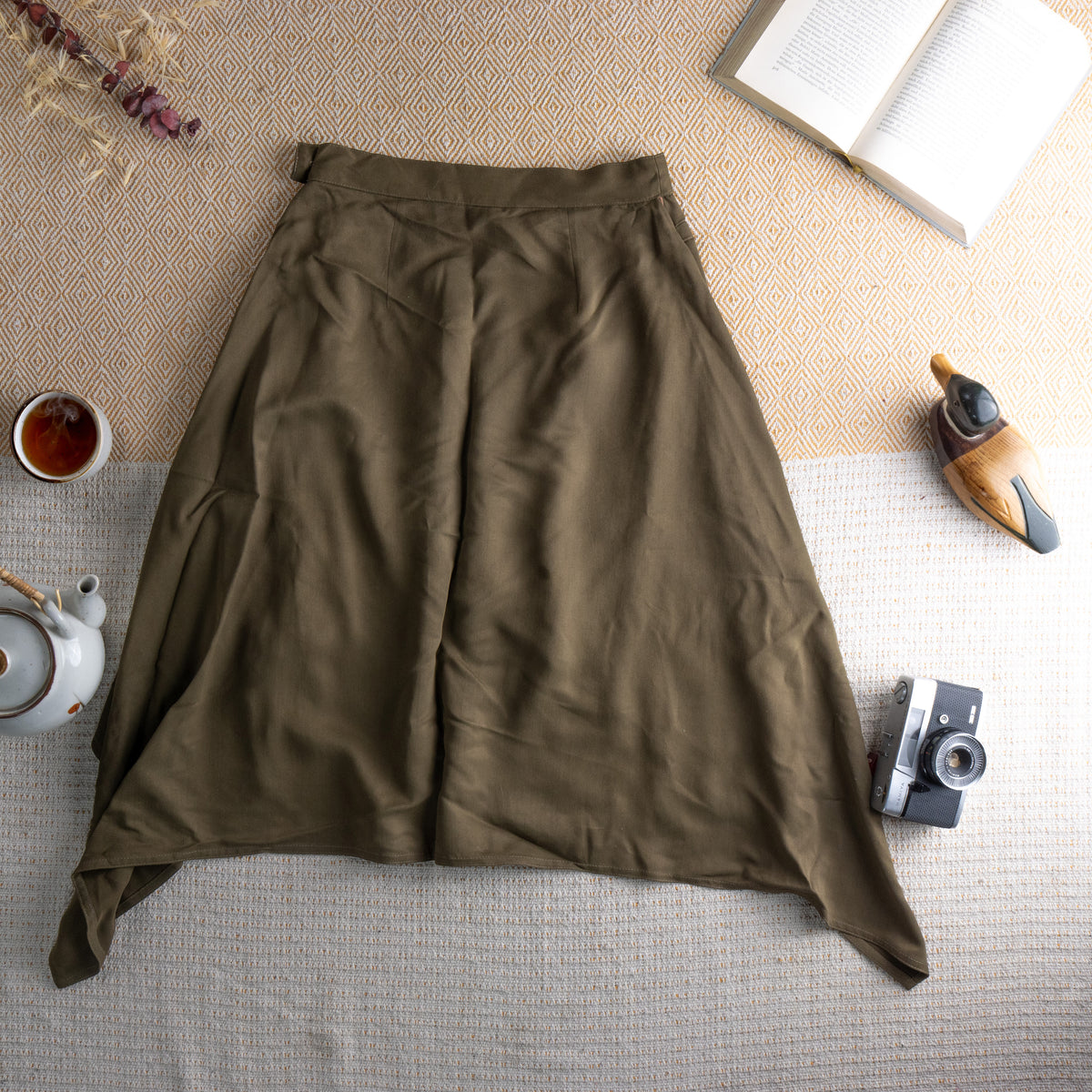 back view Vintage Max Mara 90s Silk Cupro Midi Skirt – olive army green fluid silk-cupro, high waist with single button closure, dramatic deep side slits revealing blush lining, asymmetric draped hem, minimalist Italian luxury, flat lay editorial shot