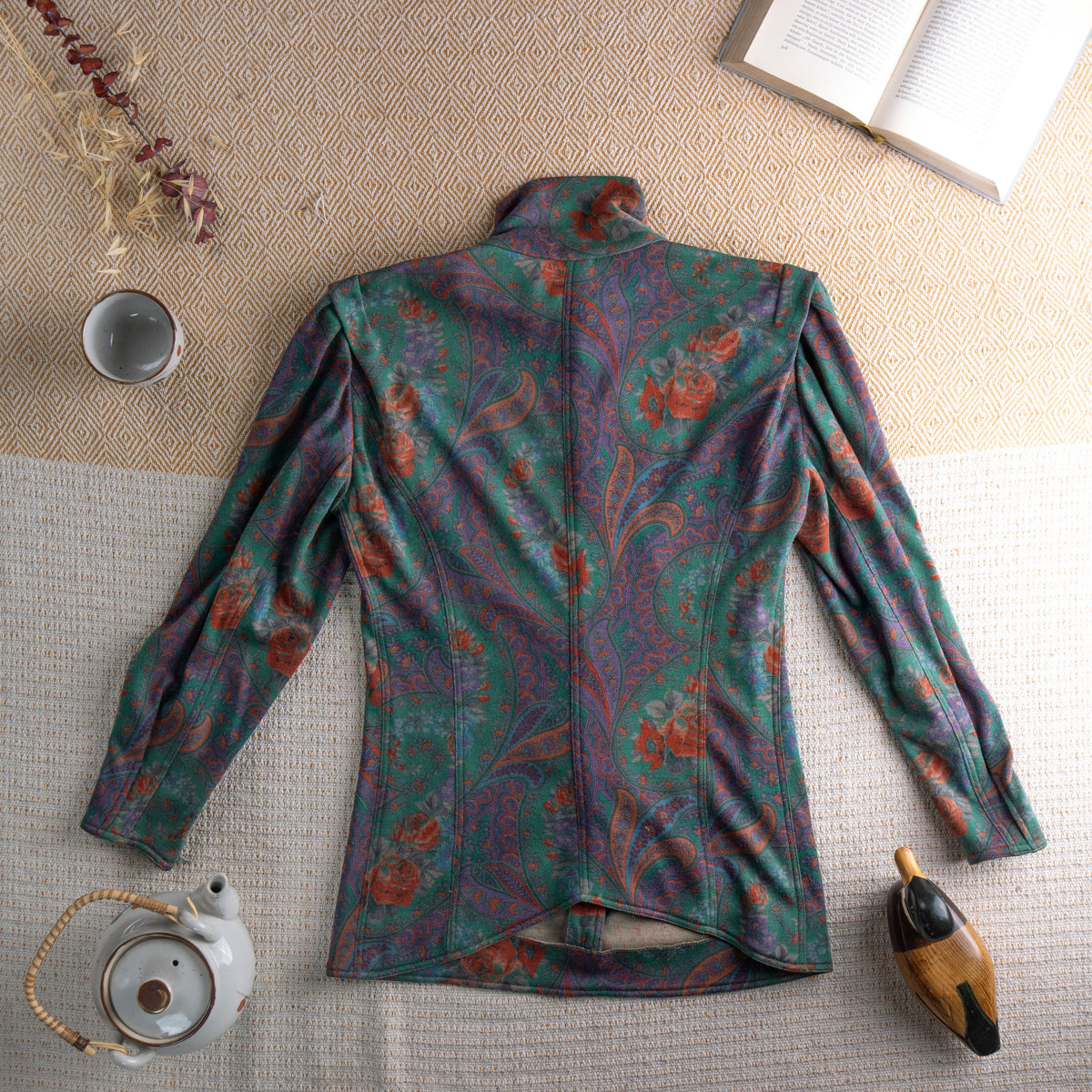 back Vintage Ungaro Parallèle Paris 80s Two-Piece Skirt Suit – emerald green, rust and mauve paisley floral jersey, high neck blouse with jewel button-front and dramatic puff shoulders, long sleeves, matching high-waist pencil midi skirt, Made in Italy, flat lay editorial shot