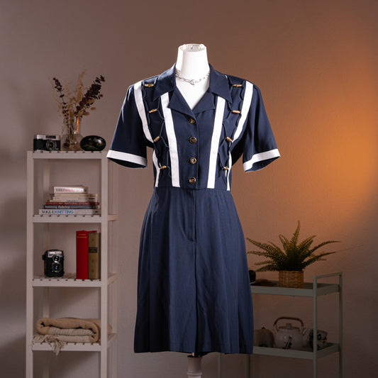 Archival Joseph Ribkoff 80s Nautical Deadstock Jumpsuit – navy blue with white vertical stripe trompe l'oeil panel detail, gold nautical rope and anchor button trim, notched lapel collar, short sleeves, pleated wide-leg trousers, strong shoulder silhouette, product shot on dress form