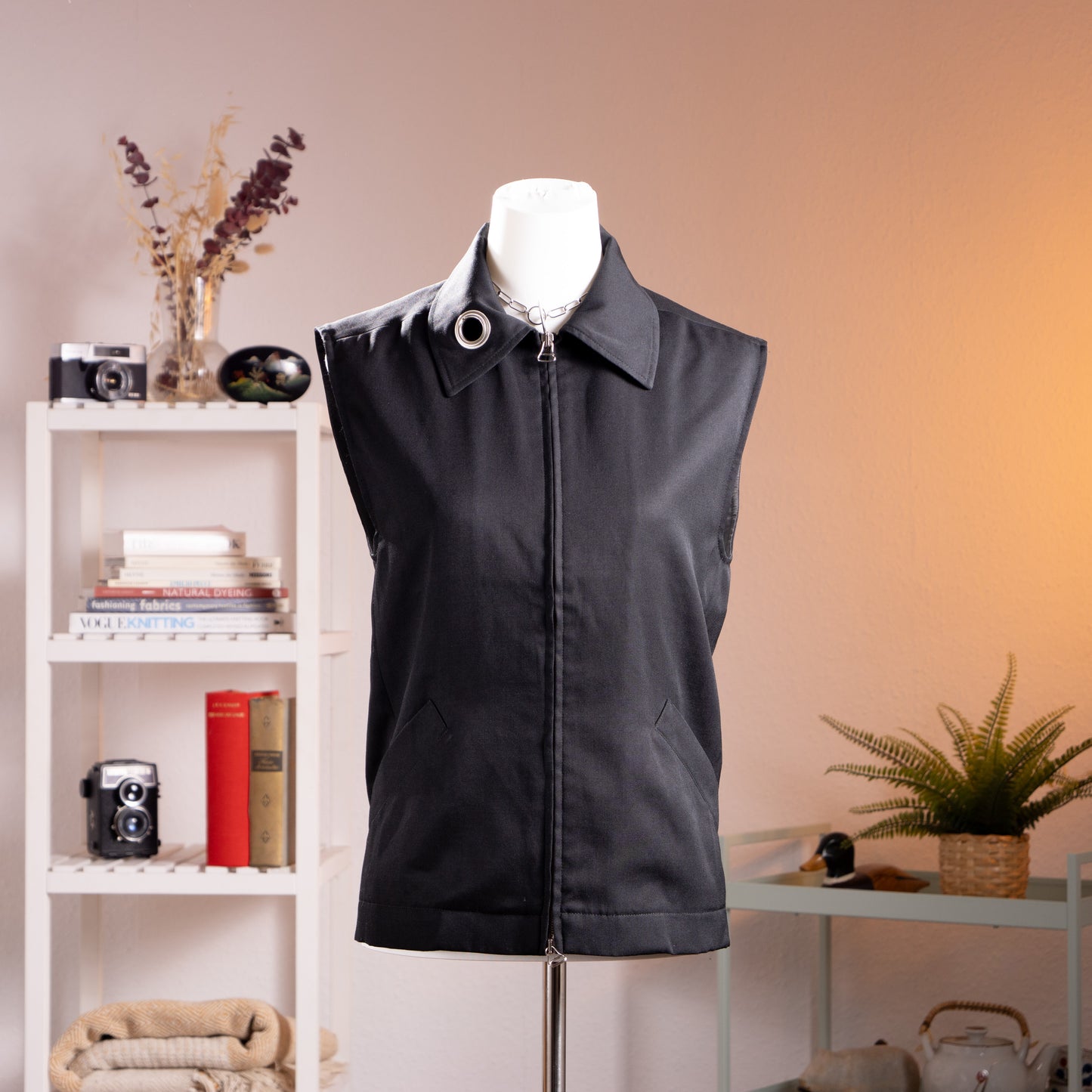 Archival Jean Colonna 90s Minimalist Industrial Grunge Vest – black cotton twill sleeveless waistcoat with point collar, full-length centre front zip with large silver eyelet ring pull detail, slash hip pockets, avant-garde utilitarian aesthetic, Made in Italy, product shot on dress form