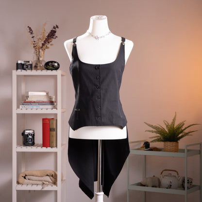 Archival Cop Copine Y2K "Helens" Asymmetrical Tailcoat Gilet – black structured vest with adjustable silver buckle shoulder straps, single-breasted button front, safety pin detail at hip pocket, dramatic asymmetrical draped tailcoat back hem, cyber grunge subversive aesthetic, product shot on dress form

