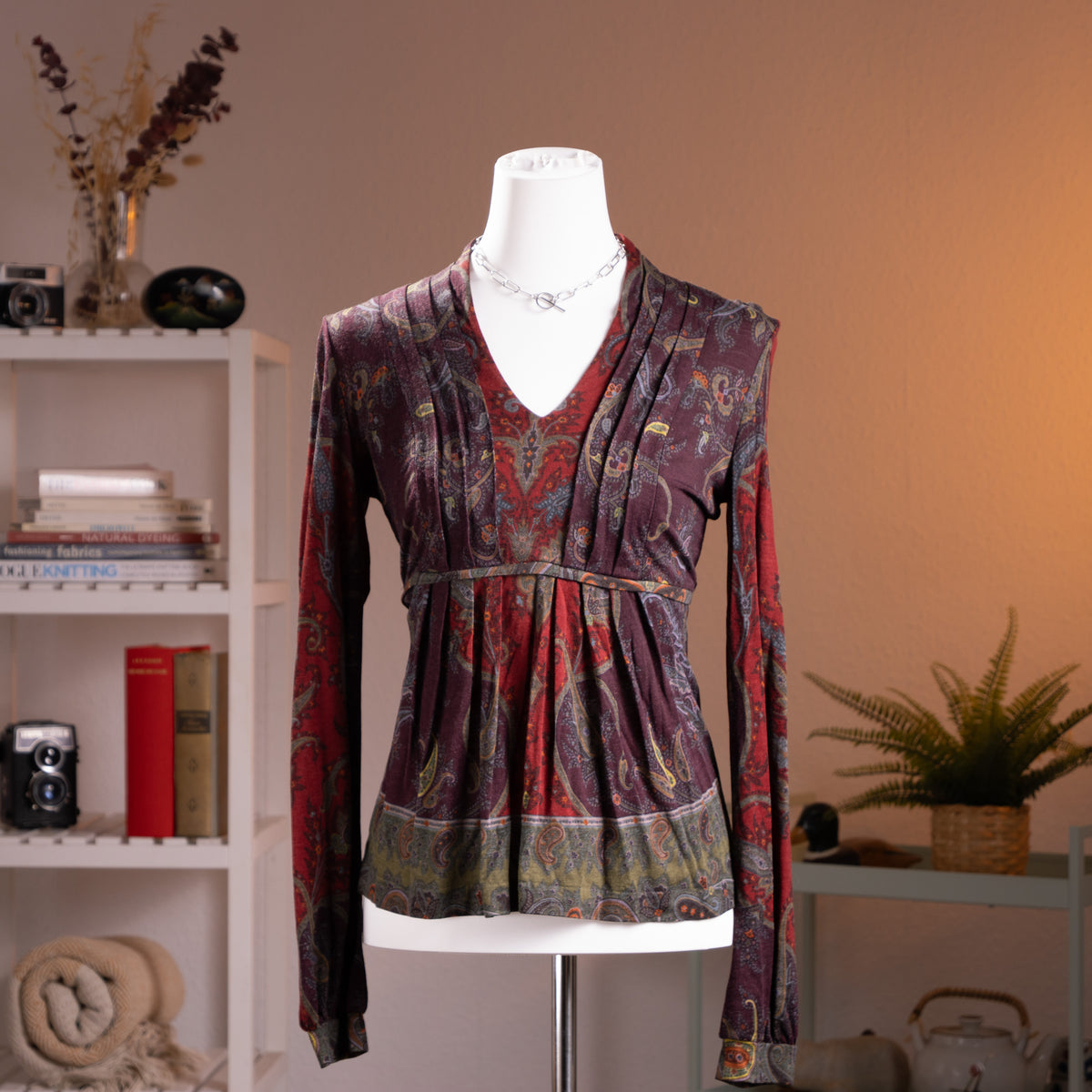 Archival Etro Milano 90s Paisley Wool Jersey Top – rich burgundy and purple wool jersey with all-over heritage paisley print in red, teal, gold and olive, deep V-neckline with draped crossover front, empire waist with gathered peplum hem, long sleeves, Made in Italy, product shot on dress form