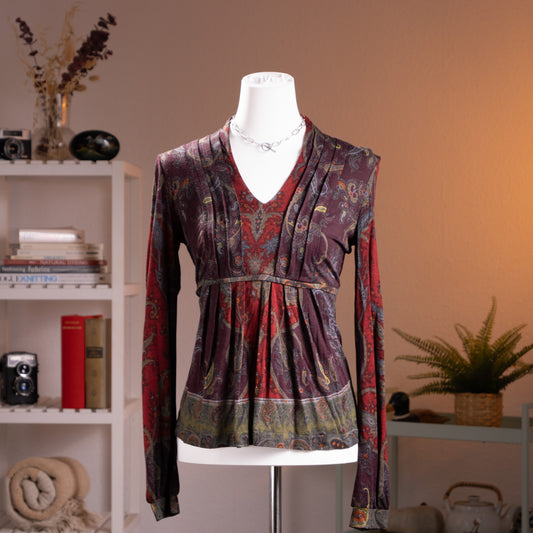 Archival Etro Milano 90s Paisley Wool Jersey Top – rich burgundy and purple wool jersey with all-over heritage paisley print in red, teal, gold and olive, deep V-neckline with draped crossover front, empire waist with gathered peplum hem, long sleeves, Made in Italy, product shot on dress form