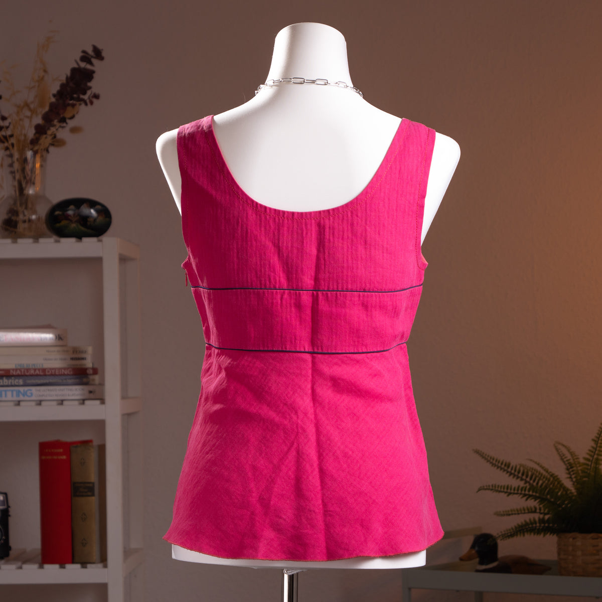 Archival Salvatore Ferragamo Fuchsia Pure Linen Peplum Top –  back view vibrant fuchsia pink linen with scoop neckline, wide shoulder straps with woven wood toggle button detail, navy blue contrast piping trim at empire waist seam, flared peplum hem, silk lined, Made in Italy, product shot on dress form