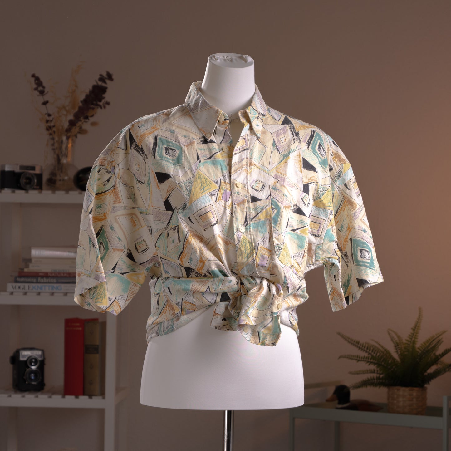 Archival Courrèges Paris 90s Modernist Abstract Print 100% Linen Shirt – cream linen with all-over geometric abstract print in teal, yellow, black and lavender, point collar, short sleeves, button-front, oversized unisex fit shown knotted at waist, avant-garde museum grade piece, product shot on dress form