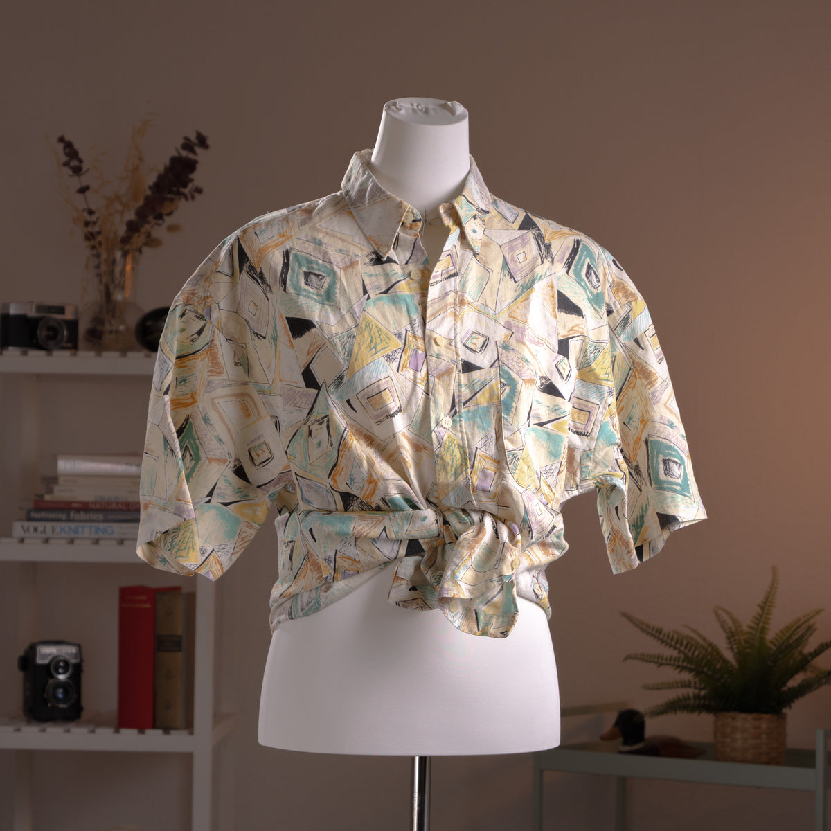 Archival Courrèges Paris 90s Modernist Abstract Print 100% Linen Shirt – cream linen with all-over geometric abstract print in teal, yellow, black and lavender, point collar, short sleeves, button-front, oversized unisex fit shown knotted at waist, avant-garde museum grade piece, product shot on dress form