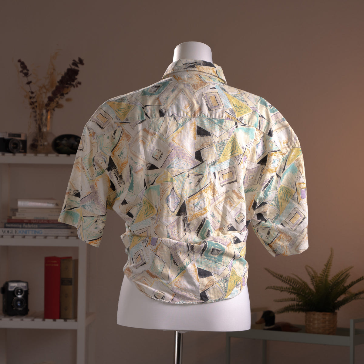 Archival Courrèges Paris 90s Modernist Abstract Print 100% Linen Shirt – cream linen with all-over geometric abstract print in teal, yellow, black and lavender, point collar, short sleeves, button-front, oversized unisex fit shown knotted at waist, avant-garde museum grade piece, product shot on dress form