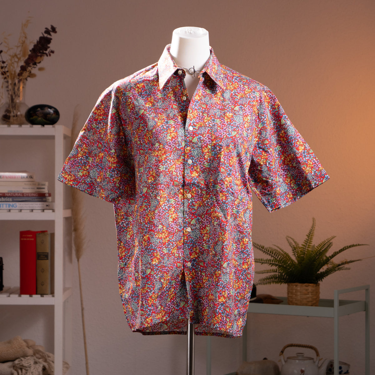 back view Archival Nina Ricci NOS Deadstock 90s Floral Print Shirt – dense Liberty-style ditsy floral print in red, pink, purple, yellow and teal on cotton, point collar, short sleeves, button-front, shown knotted at waist in dandy androgynous style, museum quality, product shot on dress form
