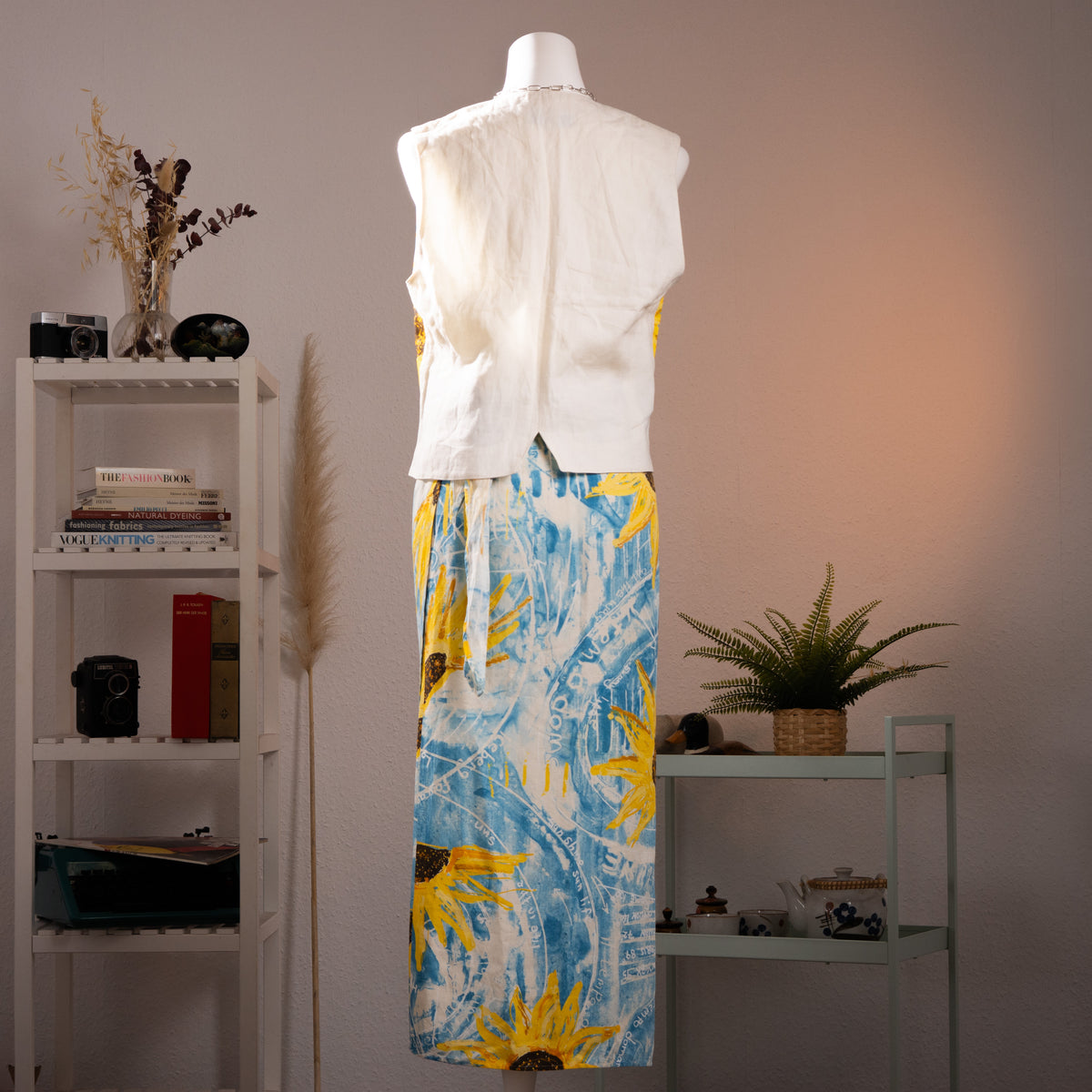 back view Archival Iceberg SS1994 Runway Linen Two-Piece Set – sky blue linen with oversized pop art sunflower and weather chart print in yellow, white and brown, sleeveless V-neck button-front vest top with pointed hem, matching midi wrap skirt, Gilmar Made in Italy, museum-quality 90s couture grail, product shot on dress form