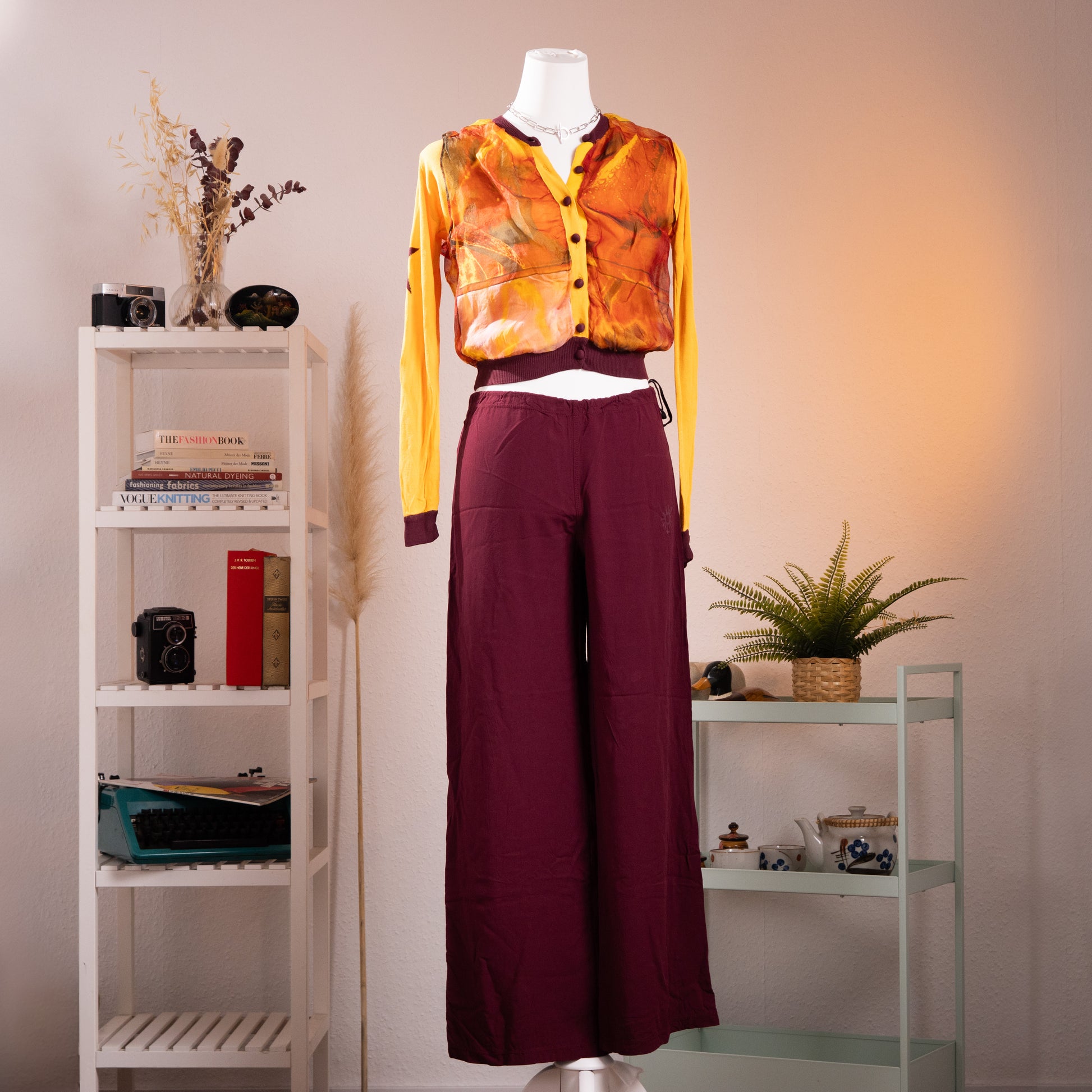 Archival Jean Paul Gaultier SS 2002 Maille Femme Two-Piece Set – mustard yellow cropped cardigan with sheer watercolour print mesh overlay in amber and green tones, burgundy contrast trim at neckline and cuffs, paired with wide-leg burgundy trousers with side tie detail, product shot on dress form