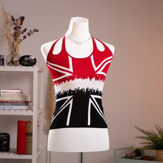 Archival Alexander McQueen 2008 Union Jack Halterneck Knit Top – red, white and black intarsia knit with deconstructed Union Jack flag motif, crowd silhouette graphic at midriff, racerback halterneck with open back, cropped fit, product shot on dress form
Autumn/Winter 2008 collection, titled „The Girl Who Lived in the Tree“