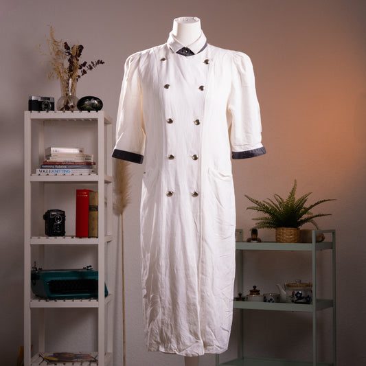 Archival Louis Féraud cream double-breasted coat dress from the 1980s, made in West Germany, displayed on a gallery mannequin in a minimalist studio setting.
