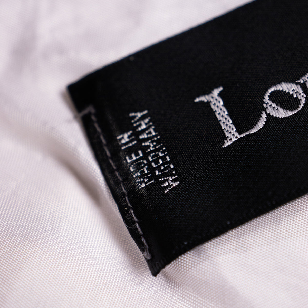 Close-up of the vintage Louis Féraud black woven satin neck label with vertical 'Made in W. Germany' text and European size matrix matrix D 40 US 10.
