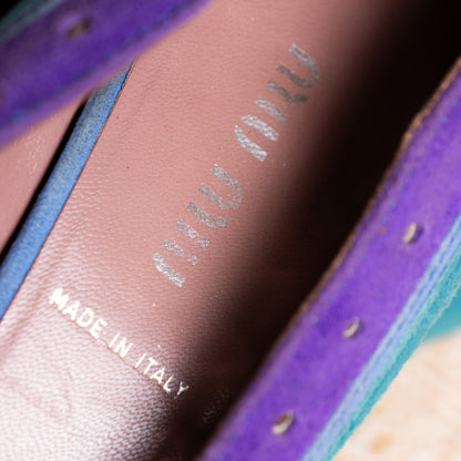  A macro photograph of the rose-tinted neutral luxury leather lining inside a Miu Miu 2005 pump. The classic metallic silver Miu Miu brand logo is crisply stamped into the heel cushion area directly above the "MADE IN ITALY" text.