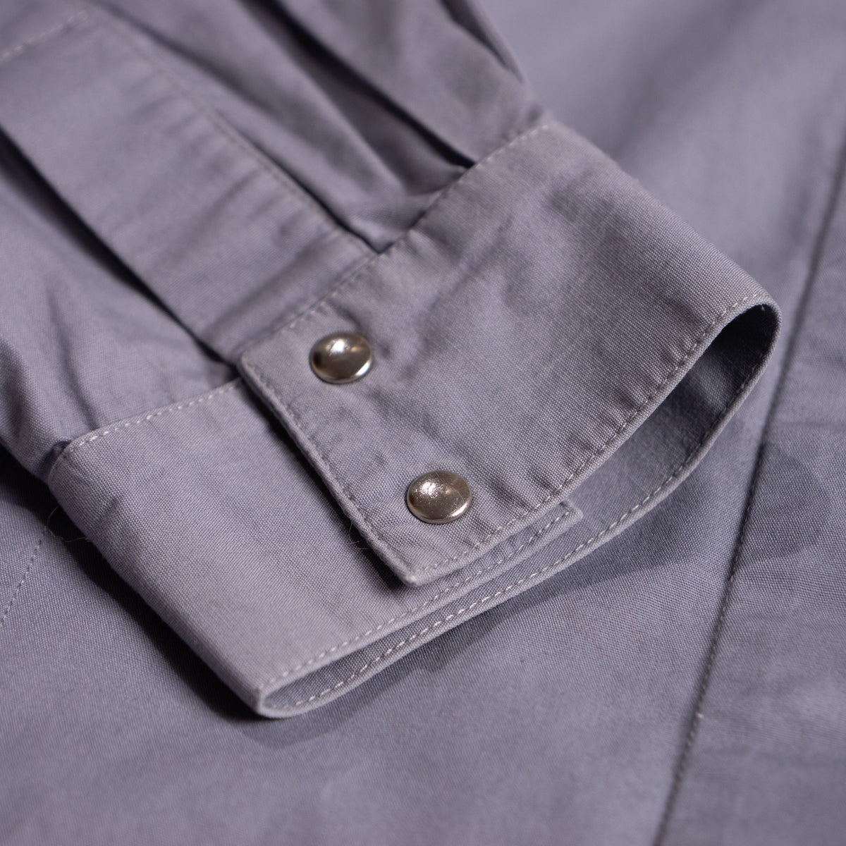 Detailed macro shot of the high-cuff sleeve tailoring and flawless fabric matrix of the archival Thierry Mugler garment.
