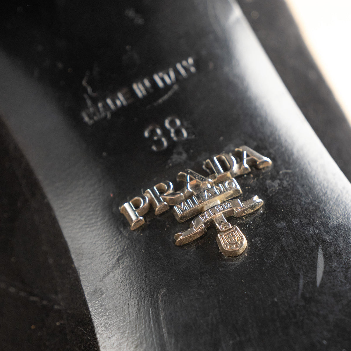 makro Prada Milano Archival 90s Black Suede Platform Block Heel Ankle Boots – jet black suede upper, square toe, chunky platform sole with engraved Prada metal logo, substantial block heel, inner zip closure with silver Prada zipper pull, Made in Italy, flat lay editorial shot