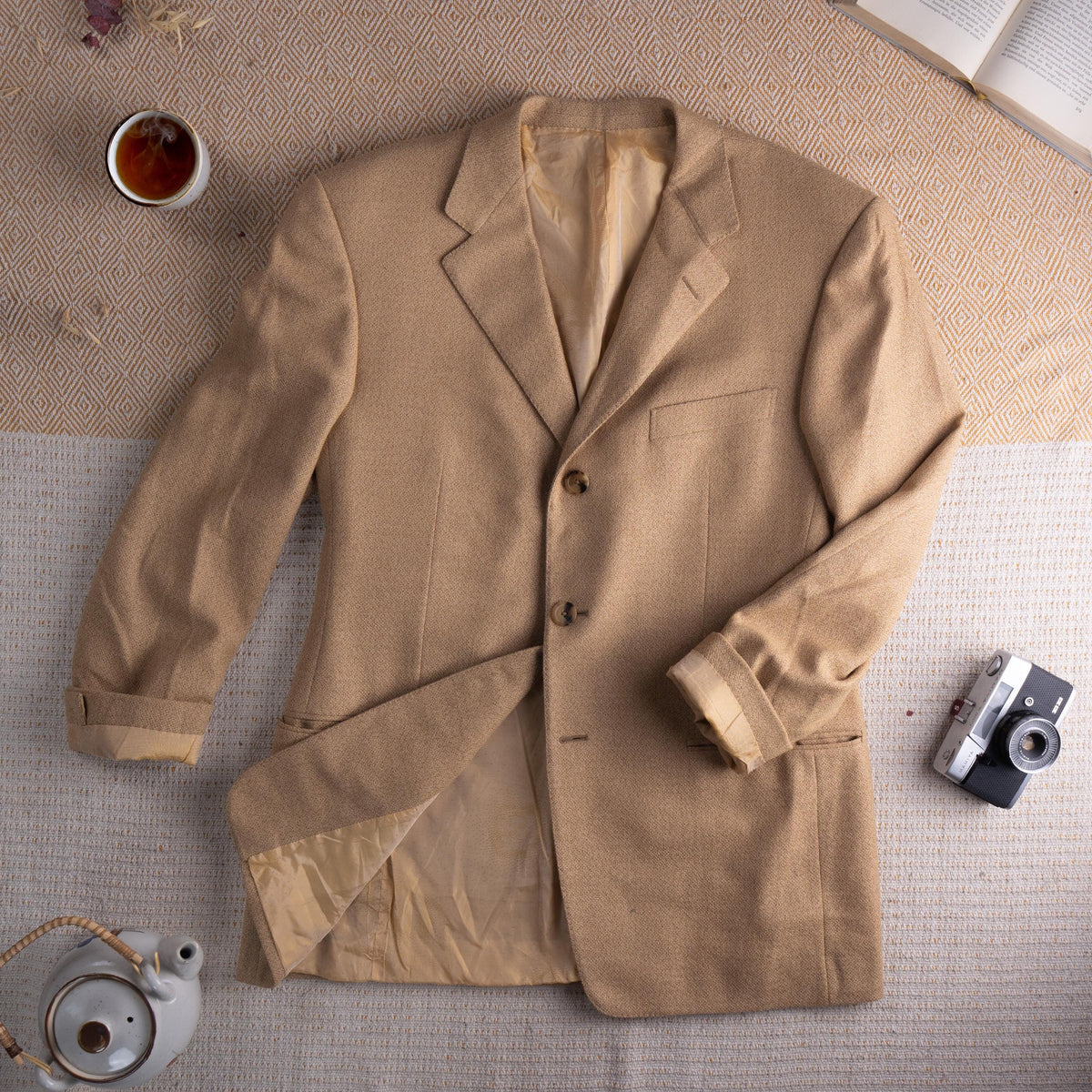 Archival Gianni Versace Couture FW1995 Hidden Medusa Trompe-l'Œil Cashmere Blazer – warm camel tan fine cashmere tweed, peak lapel, three-button single-breasted front, chest welt pocket, two lower flap pockets, silk lining with hidden Medusa trompe-l'œil print, turn-back cuffs, oversized relaxed fit IT 52, rare archival collector piece, flat lay editorial shot