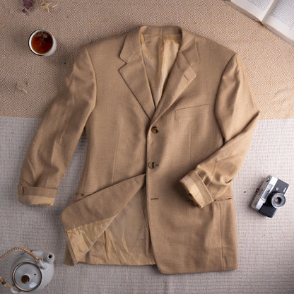 Archival Gianni Versace Couture FW1995 Hidden Medusa Trompe-l'Œil Cashmere Blazer – warm camel tan fine cashmere tweed, peak lapel, three-button single-breasted front, chest welt pocket, two lower flap pockets, silk lining with hidden Medusa trompe-l'œil print, turn-back cuffs, oversized relaxed fit IT 52, rare archival collector piece, flat lay editorial shot