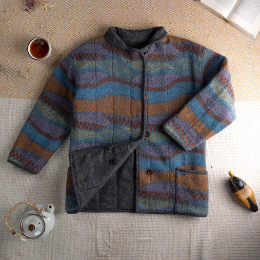 Archival Missoni Early 1990s Orange Label Reversible Fiammato Wave Quilted Jacket – multicolour mohair blend fiammato knit with undulating wave stripe pattern in teal blue, burnt amber, mauve and olive, stand collar, four dark horn button front closure, two patch pockets, reverses to solid charcoal grey herringbone tweed, flat lay editorial shot showing both sides
