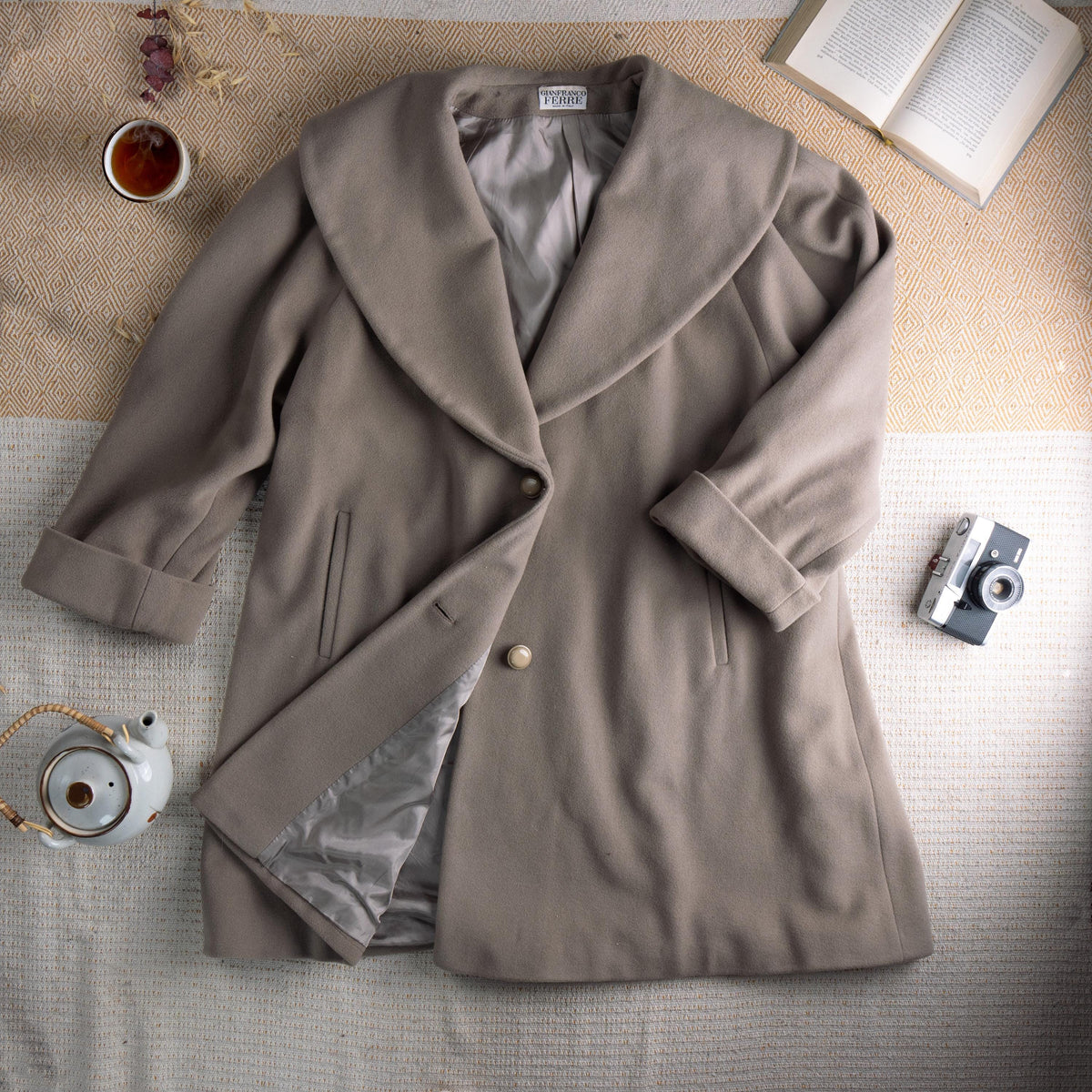 Archival Gianfranco Ferré Late 1980s Architectural Shawl Collar Cocoon Coat – warm taupe greige fine wool, oversized sculptural shawl collar, single large pearl button closure, two vertical welt pockets, wide turn-back cuffs, cocoon silhouette with silver satin lining, Gianfranco Ferré mainline woven label, rare masterpiece, flat lay editorial shot