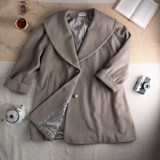 Archival Gianfranco Ferré Late 1980s Architectural Shawl Collar Cocoon Coat – warm taupe greige fine wool, oversized sculptural shawl collar, single large pearl button closure, two vertical welt pockets, wide turn-back cuffs, cocoon silhouette with silver satin lining, Gianfranco Ferré mainline woven label, rare masterpiece, flat lay editorial shot