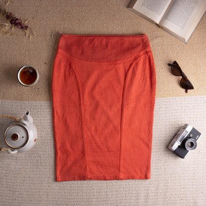 Archival Thierry Mugler Maille 1990s Coral Orange Anatomical Panel Pencil Skirt – warm coral orange stretch knit, wide ribbed hourglass waistband with fine vertical rib texture, curved anatomical seam panelling at front, body-con midi pencil silhouette, rare Mugler Maille label, IT 46 EU 38, flat lay editorial shot