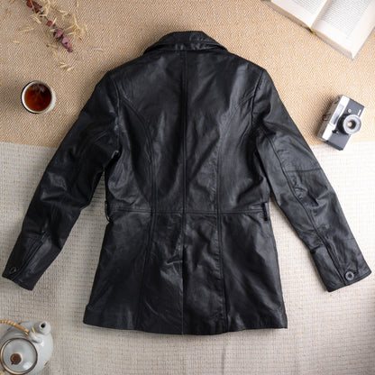 back view Deadstock XX by Mexx 90s Black Leather Longline Blazer – soft black genuine leather, wide notch lapel, three black button single-breasted front, princess seam panelling for fitted waist, two front hip pockets, quilted lining, long sleeves, minimalist matrix Y2K silhouette, red XX by Mexx label, flat lay editorial shot