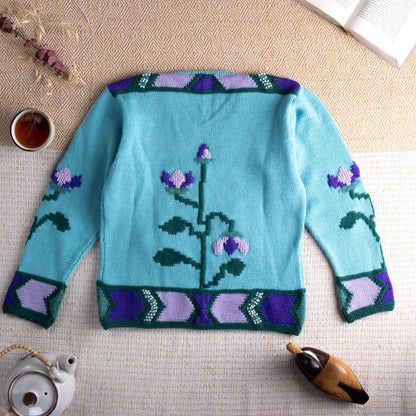 back view Archival Dior D Uniforme Floral Beaded Wool Sweater – aqua mint blue wool knit with large-scale 3D intarsia bellflower and vine motif in forest green, lavender and purple, pearl bead embellishment at neckline and hem border, geometric chevron border in purple, lavender and green at cuffs and hem, crew neck, long sleeves, special event staff piece Made in Italy, flat lay editorial shot