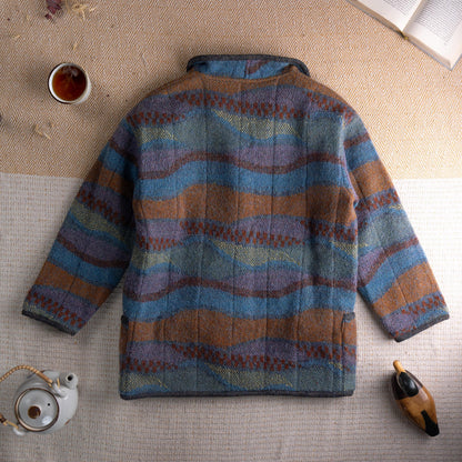 back view  Archival Missoni Early 1990s Orange Label Reversible Fiammato Wave Quilted Jacket – multicolour mohair blend fiammato knit with undulating wave stripe pattern in teal blue, burnt amber, mauve and olive, stand collar, four dark horn button front closure, two patch pockets, reverses to solid charcoal grey herringbone tweed, flat lay editorial shot showing both sides