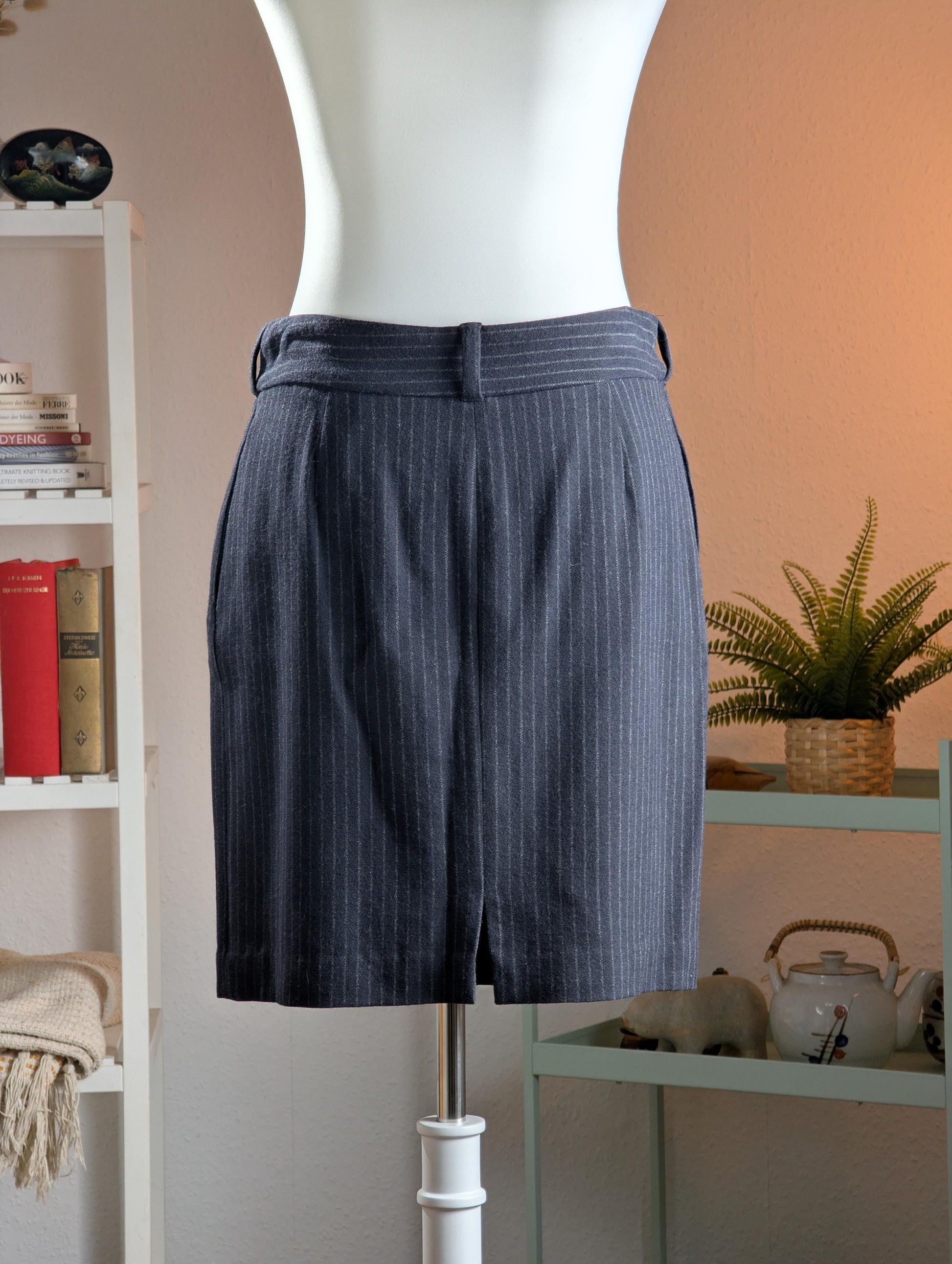 back view Archival Victor Alfaro Deadstock 90s Pinstripe Virgin Wool Mini Pencil Skirt – charcoal grey fine virgin wool with white chalk pinstripe, mid-rise waistband with belt loops, two front slant pockets, straight mini pencil silhouette with back kick vent, deadstock unworn condition, Made in Italy, corporate chic office siren, product shot on dress form