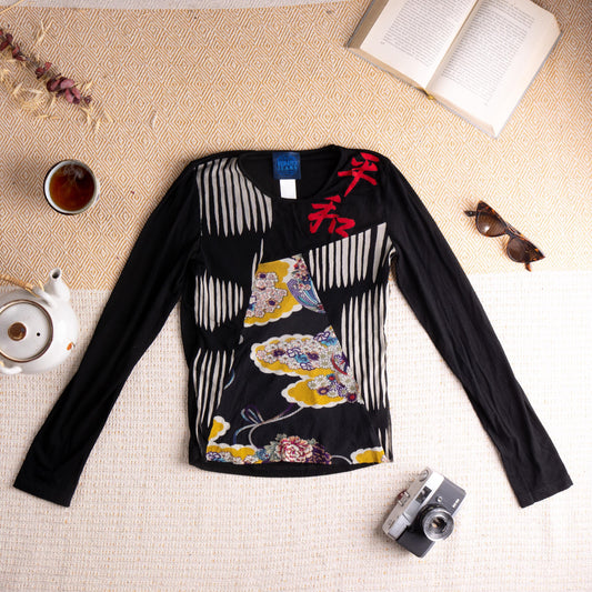 Archival Kenzo Jeans 1990s Kimono Trompe-l'Œil Mesh Top – black viscose long-sleeve body with sheer mesh front panel featuring shibori-style vertical stripe print, trompe-l'œil kimono floral motif with yellow cloud and peony blossom detail, bold red kanji character print at chest, V-neckline, fitted silhouette, Made in Italy, flat lay editorial shot