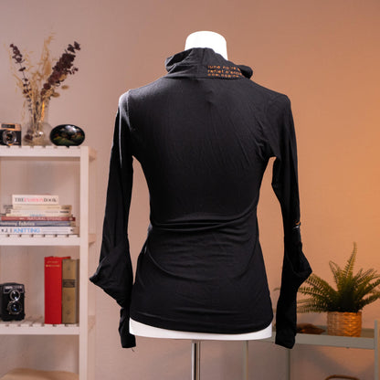 back view Rare Archival Cop Copine "Gridley" 90s Deconstructed Noir Top – jet black stretch jersey, asymmetric draped cowl turtleneck with red "c de mystère" embroidered text at collar, silver hardware buckle detail at neck and cuffs, long sleeves with open split cuff, fitted silhouette, French avant-garde minimalist cyber, product shot on dress form