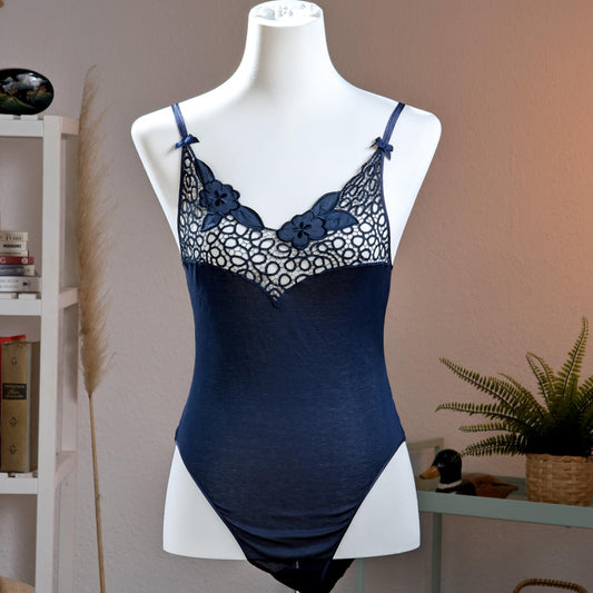 Archival La Perla Tricot NOS Deadstock 90s Navy Blue Bodysuit – navy blue stretch jersey with sheer guipure lace décolleté panel featuring 3D appliqué floral embroidery, adjustable spaghetti straps with bow detail, V-neckline, thong cut, Italian museum grade lingerie, product shot on dress form