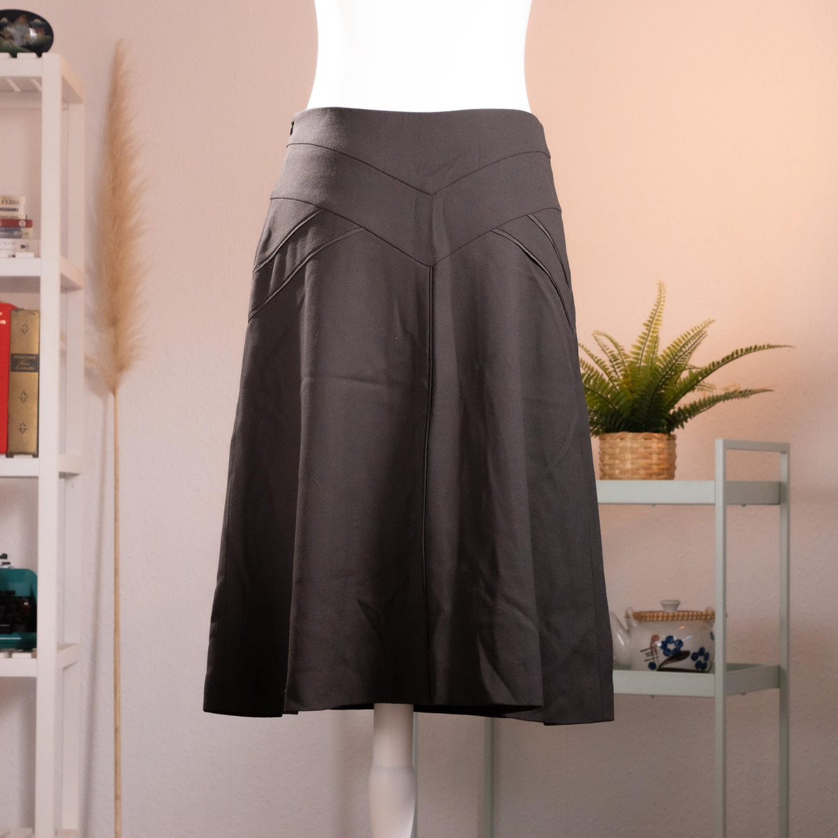 Archival Nina Ricci Sculptural Chevron-Yoke Virgin Wool Midi Skirt – anthracite charcoal grey melange fine wool, wide structured V-chevron yoke waistband with topstitched seam detail, flared A-line midi silhouette, silk lining, back zip closure, Peter Copping era precision tailoring, product shot on dress form