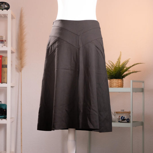 Archival Nina Ricci Sculptural Chevron-Yoke Virgin Wool Midi Skirt – anthracite charcoal grey melange fine wool, wide structured V-chevron yoke waistband with topstitched seam detail, flared A-line midi silhouette, silk lining, back zip closure, Peter Copping era precision tailoring, product shot on dress form