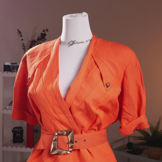 Archival Thierry Mugler ACTIV 1992 3-Piece Skirt Suit – vibrant coral orange linen blend, structured wrap blazer with deep V-neckline, short sleeves, gold pyramid hardware stud buttons, matching wide belt with large gold pyramid buckle for extreme wasp waist silhouette, pencil mini skirt, product shot on dress form